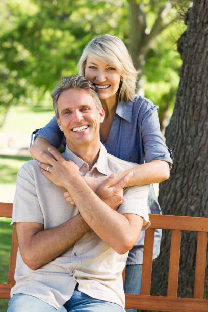 istock Woman embracing man from behind in park 690302742