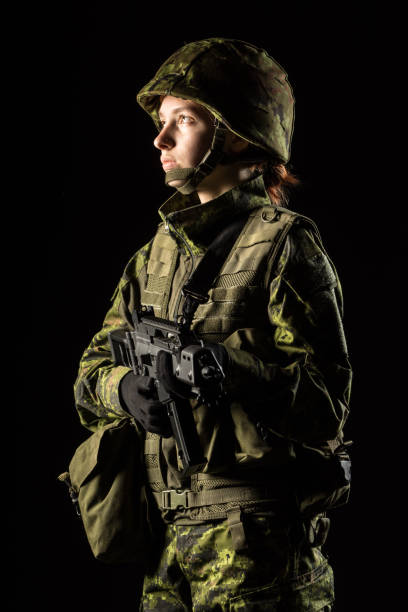 portrait of armed woman with camouflage. young female soldier observe with firearm. child soldier with gun in war, black background.  military, army people concept - airsoft gun imagens e fotografias de stock