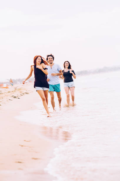istock Friends running on the beach 690303226