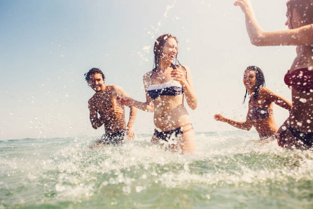 istock Friends splashing each other with water 690303238