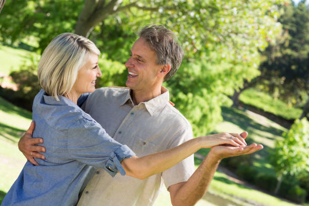 Couple dancing in park Happy loving couple dancing in park middle aged couple dancing stock pictures, royalty-free photos & images