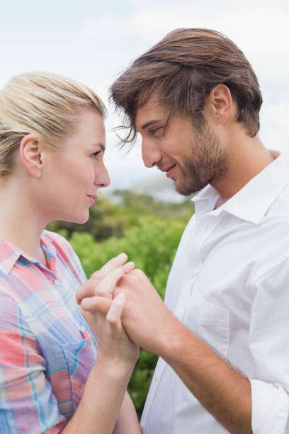 istock Cute affectionate couple standing outside holding hands 690304592