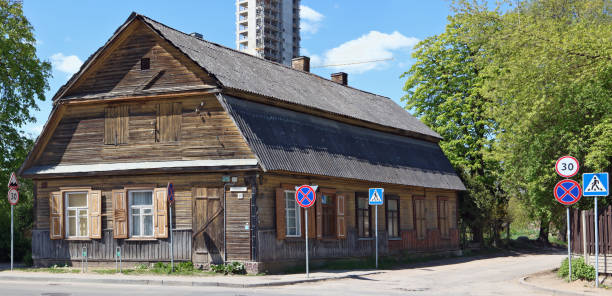 wilno, litwa- 14 maja 2017: starożytny drewniany dom z budową końca xix wieku przy ulicy giedraiciu. w pobliżu powstaje nowy wieżowiec - 19th of may zdjęcia i obrazy z banku zdjęć