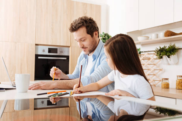 istock Daughter looking at drawing of her father 690313646
