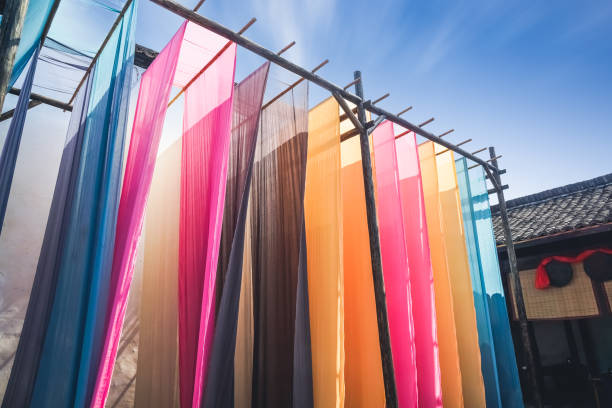 colorful fabric hanging to dry after traditional dye process stock photo
