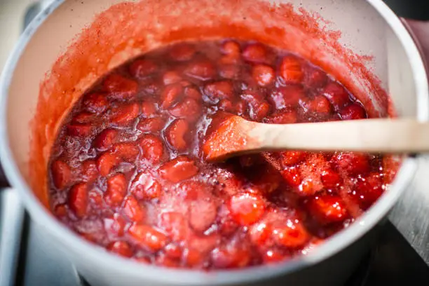 Photo of Close up of a simmering homemade strawberry jam.