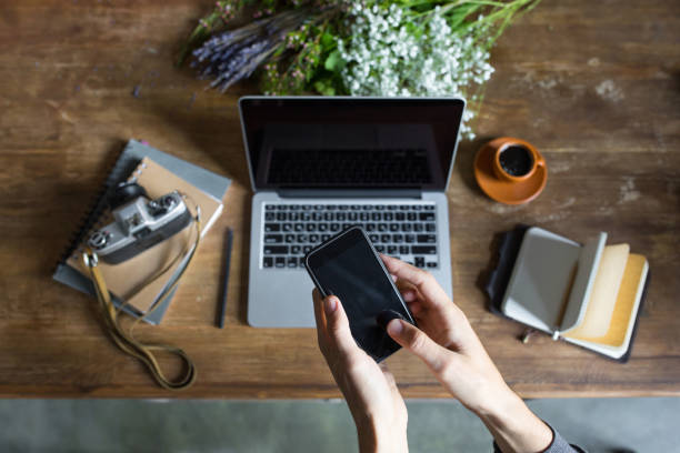 istock person using smartphone and laptop at workspace with notebooks and vintage camera 690316182