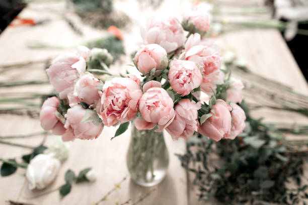 pink peonies in vase on wooden floor and bokeh background - retro styled photo. soft focus. - flower arrangement flower bouquet arrangement imagens e fotografias de stock