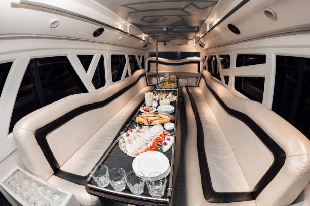 interno all'interno della limousine. con divani e un tavolo coperto di snack per la vacanza. messa a fuoco selettiva - limousine interno foto e immagini stock
