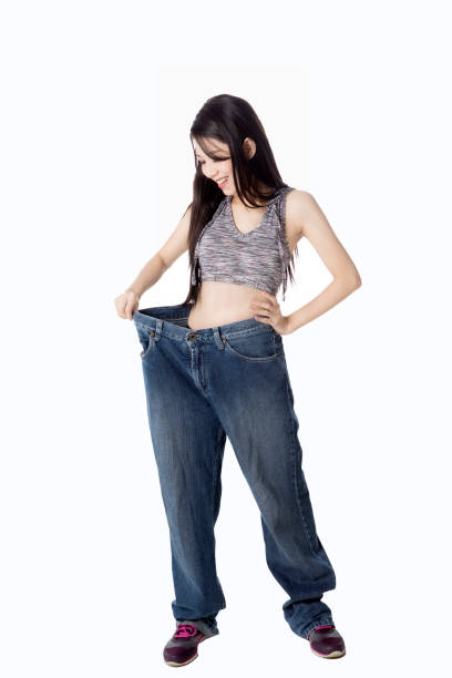 istock Young woman wears big jeans 690339290