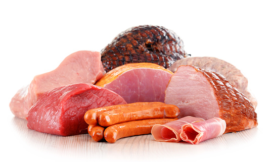 Assorted meat products including ham and sausages isolated on white background