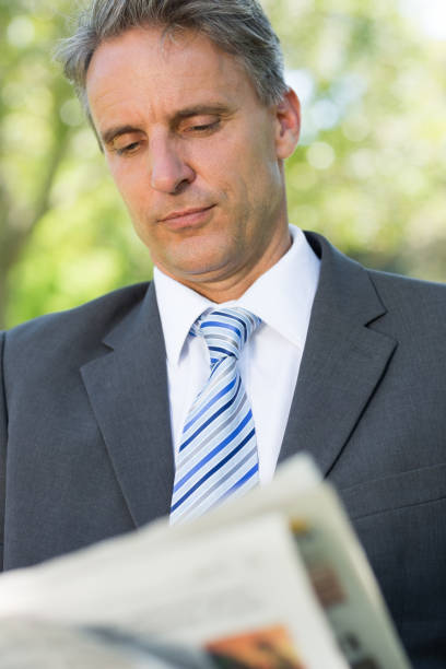 istock Businessman reading newspaper 690346432