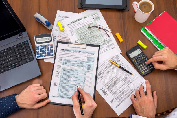 istock two people filling tax forms, helping each other. 690346452