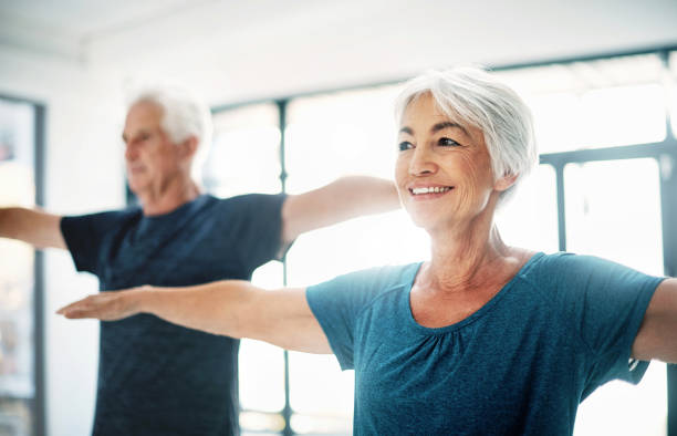 try to maintain healthy fitness habits, no matter your age - relaxation exercise stretching exercising women imagens e fotografias de stock