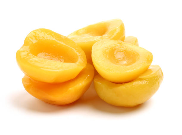 istock Canned peach on syrup over white background 690356972