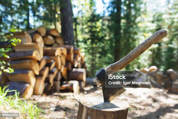 Old Axe Standing Against A Piled Pieces Of Firewood Stock Photo - Download Image Now