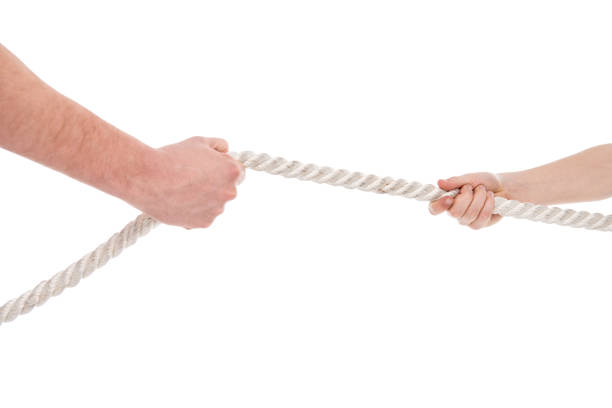 istock Close-up partial view of father and son pulling rope, family problems concept 690357824