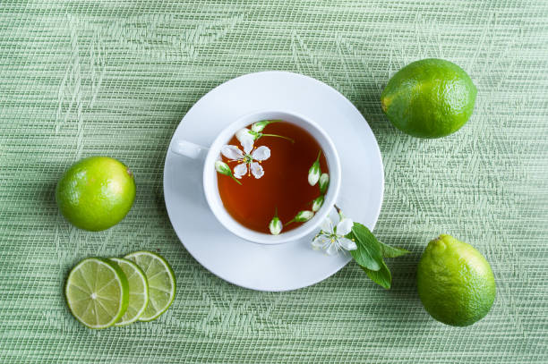 차 백색 컵입니다. 녹색, 검정, 초본, 재 스민 차 레몬과 생강. 차 테마입니다. 밝은 초록색, 민트 배경 - mint tea lemon tea leaves glass 뉴스 사진 이미지
