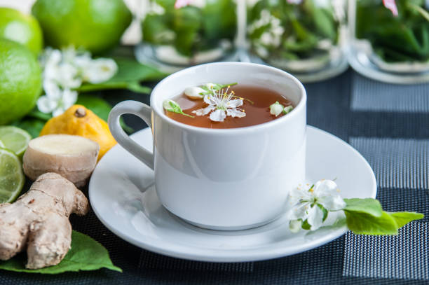 copo branco com chá. verde, preto, ervas, jasmine chá com limão e gengibre. - mint tea lemon tea leaves glass - fotografias e filmes do acervo