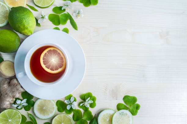 copo branco com chá. verde, preto, ervas, jasmine chá com limão e gengibre. fundo com espaço para texto. tema do chá. - mint tea lemon tea leaves glass - fotografias e filmes do acervo