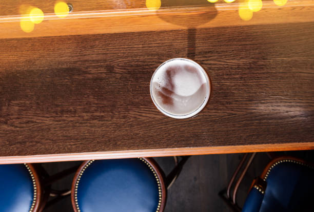 Glass of fresh beer on pub counter Glass of fresh beer on pub table, view from above open space bar stock pictures, royalty-free photos & images