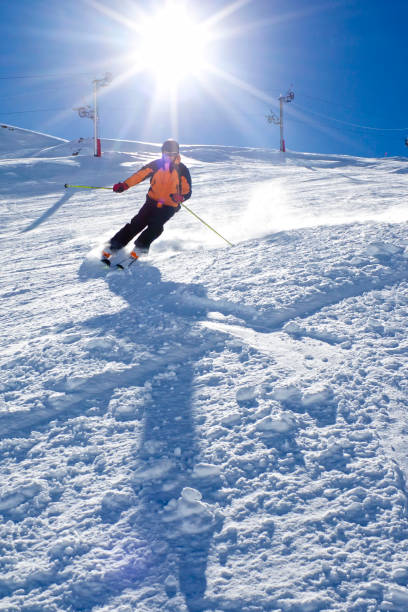 istock guy turning in the snow with the sun behind him 690389586