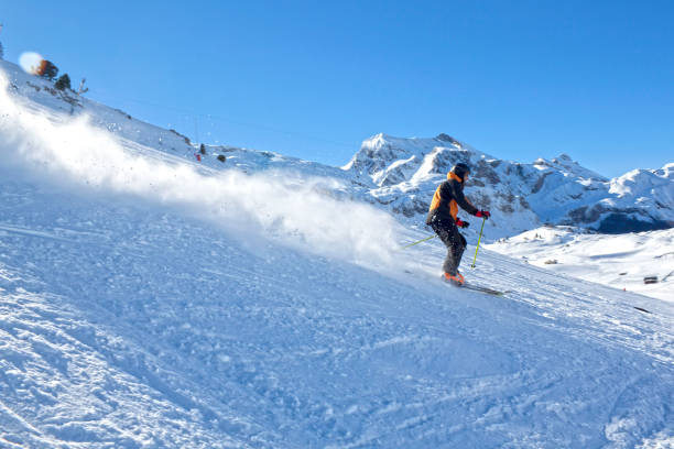 istock skier going down the mountain very fast in a sunny day 690389612