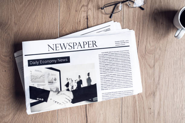 istock Newspaper on wooden table 690396078