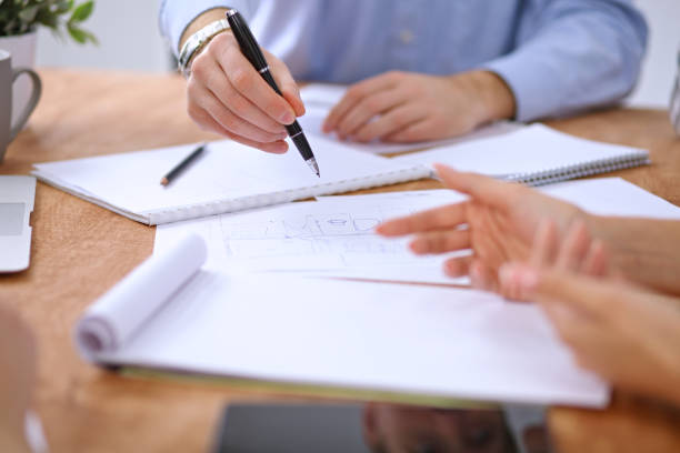 istock Hands of business people meeting around table 690398216