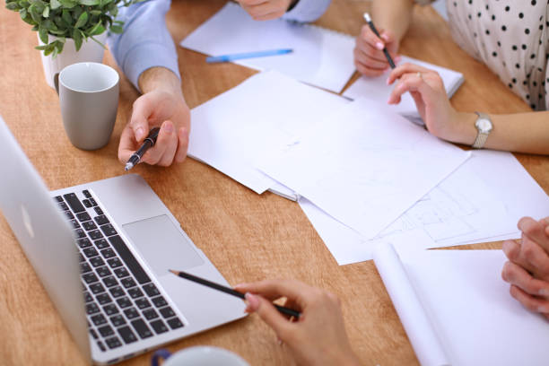 istock Hands of business people meeting around table 690400508
