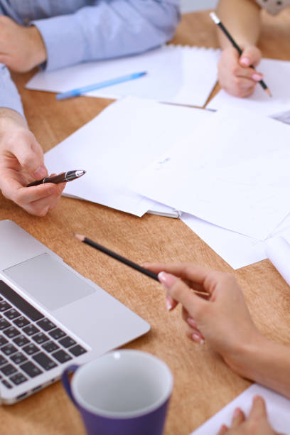 istock Hands of business people meeting around table 690400538