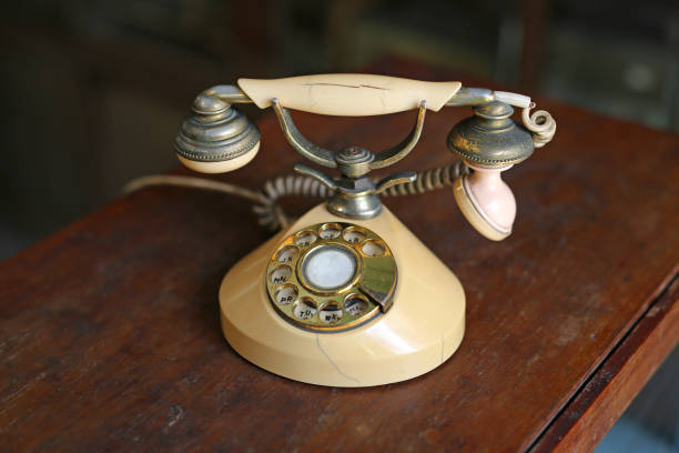 istock Retro beige rotary phone on wooden table. 690403960