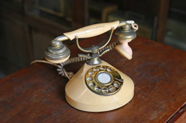 istock Retro beige rotary phone on wooden table. 690404028