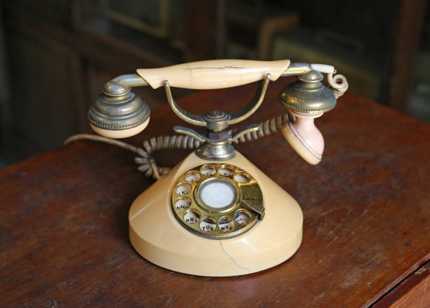 istock Retro beige rotary phone on wooden table. 690404076