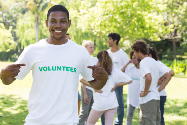 istock Volunteer pointing at tshirt in park 690404094
