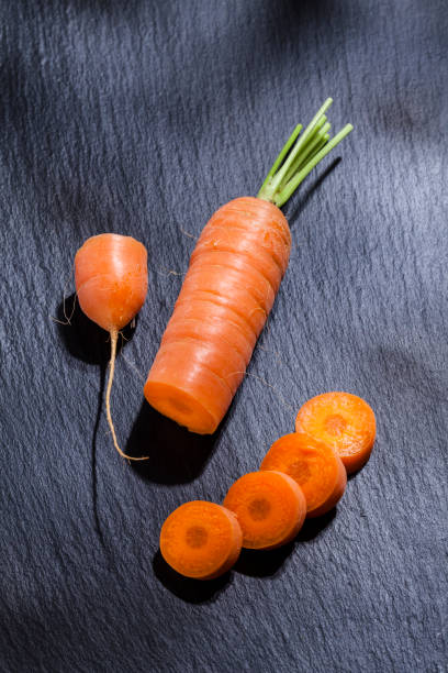 istock Organic carrot on black slate background 690404320