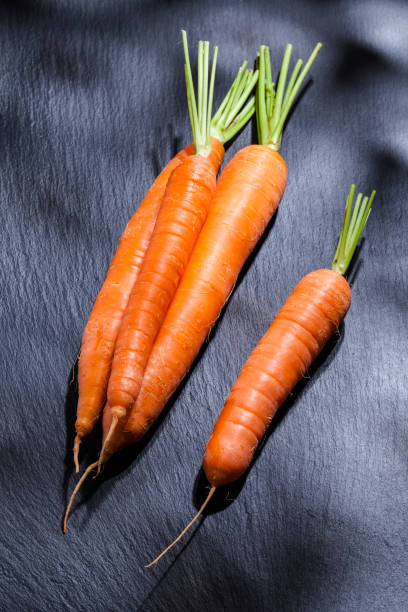istock Organic carrots on black slate background 690404364