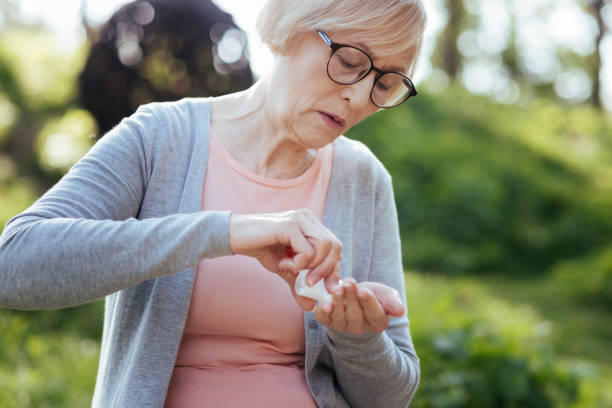 istock Retired woman taking pills in the park 690404510