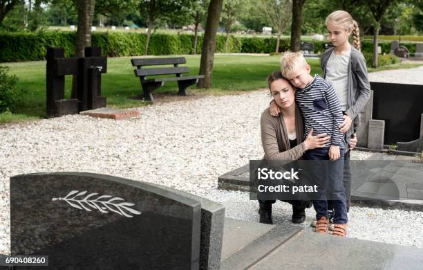 Young Family Visiting Grave Of Family Stock Photo - Download Image Now - Child, Funeral, Family