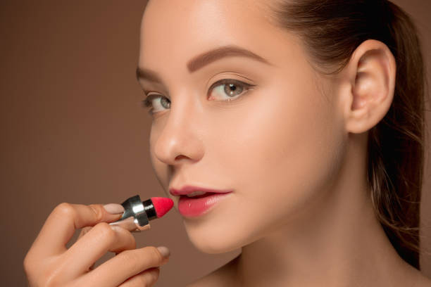 istock Beautiful female lips with make-up and brush 690408508