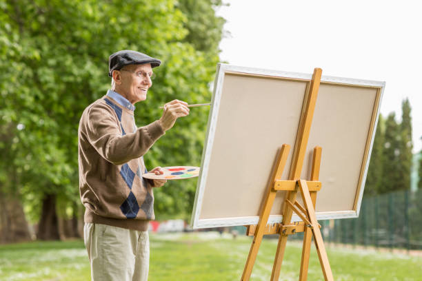 キャンバスに絵を描く年配の男性 ストックフォト