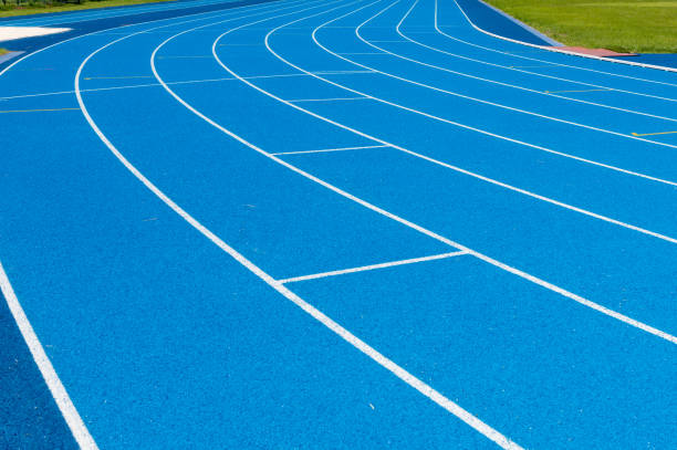 Blue Running track .Lanes of blue running track.Running track with blue asphalt and white markings in outdoor stadium.selective focus. Blue Running track .Lanes of blue running track.Running track with blue asphalt and white markings in outdoor stadium.selective focus. rubberized stock pictures, royalty-free photos & images