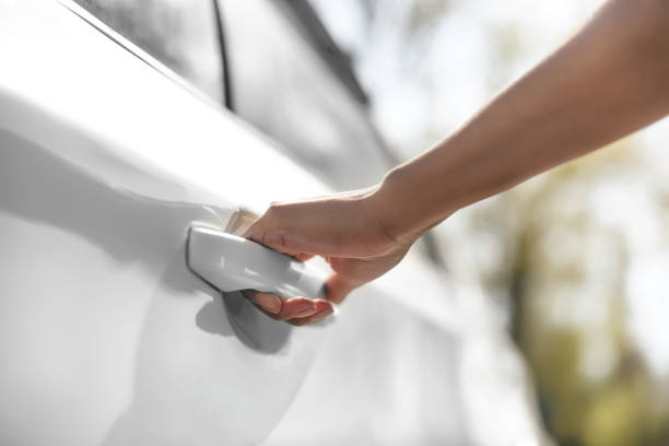 vista parziale della donna che apre porta auto sul parcheggio - maniglia foto e immagini stock