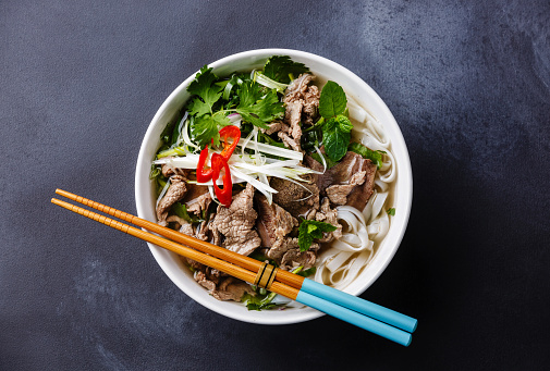 Pho Bo vietnamese Soup with beef on dark background