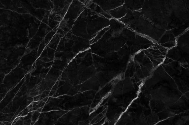 istock Black and dark marble texture shot through with white deep veining 690415676