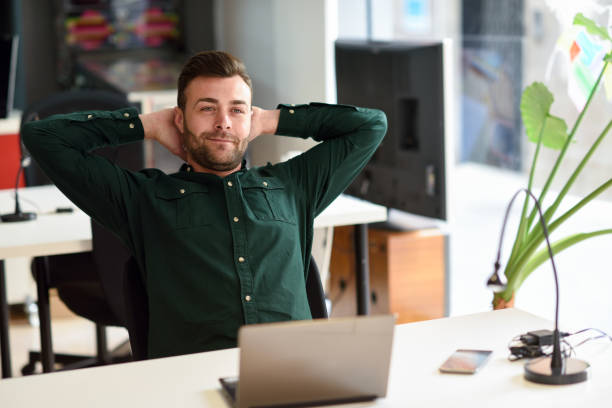istock Young man studying with laptop computer on white desk. 690418856