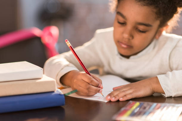istock african american schoolgirl doing homework, elementary school student concept 690419122