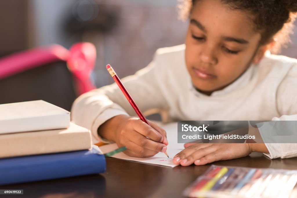african american schoolgirl doing homework, elementary school student concept Child Stock Photo