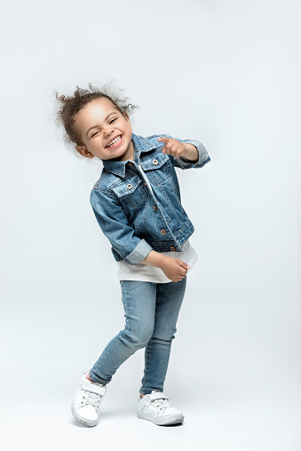funny little kid girl in jeans isolated on white