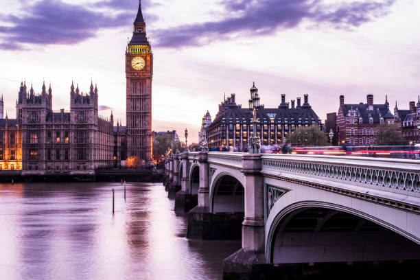istock Big Ben and Westminster bridge at night with car light trails 690419928